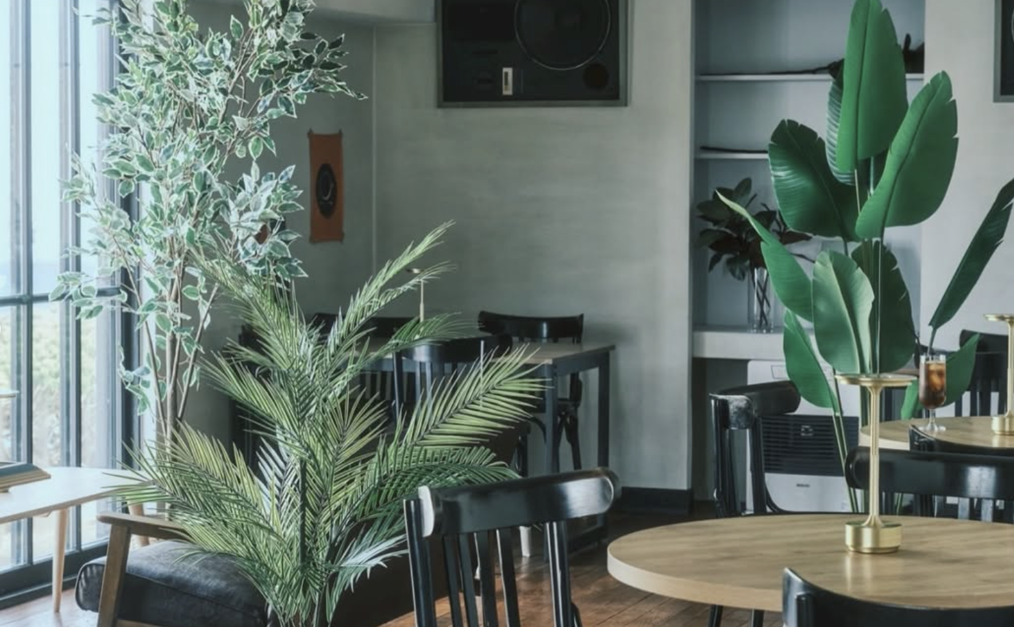 観葉植物と木のテーブルがあるCAFE de TORYの店内